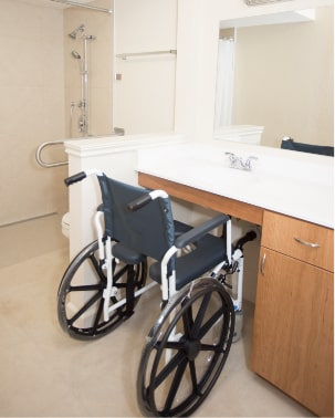 Wheelchair positioned at the bathroom sink after the accessibility project