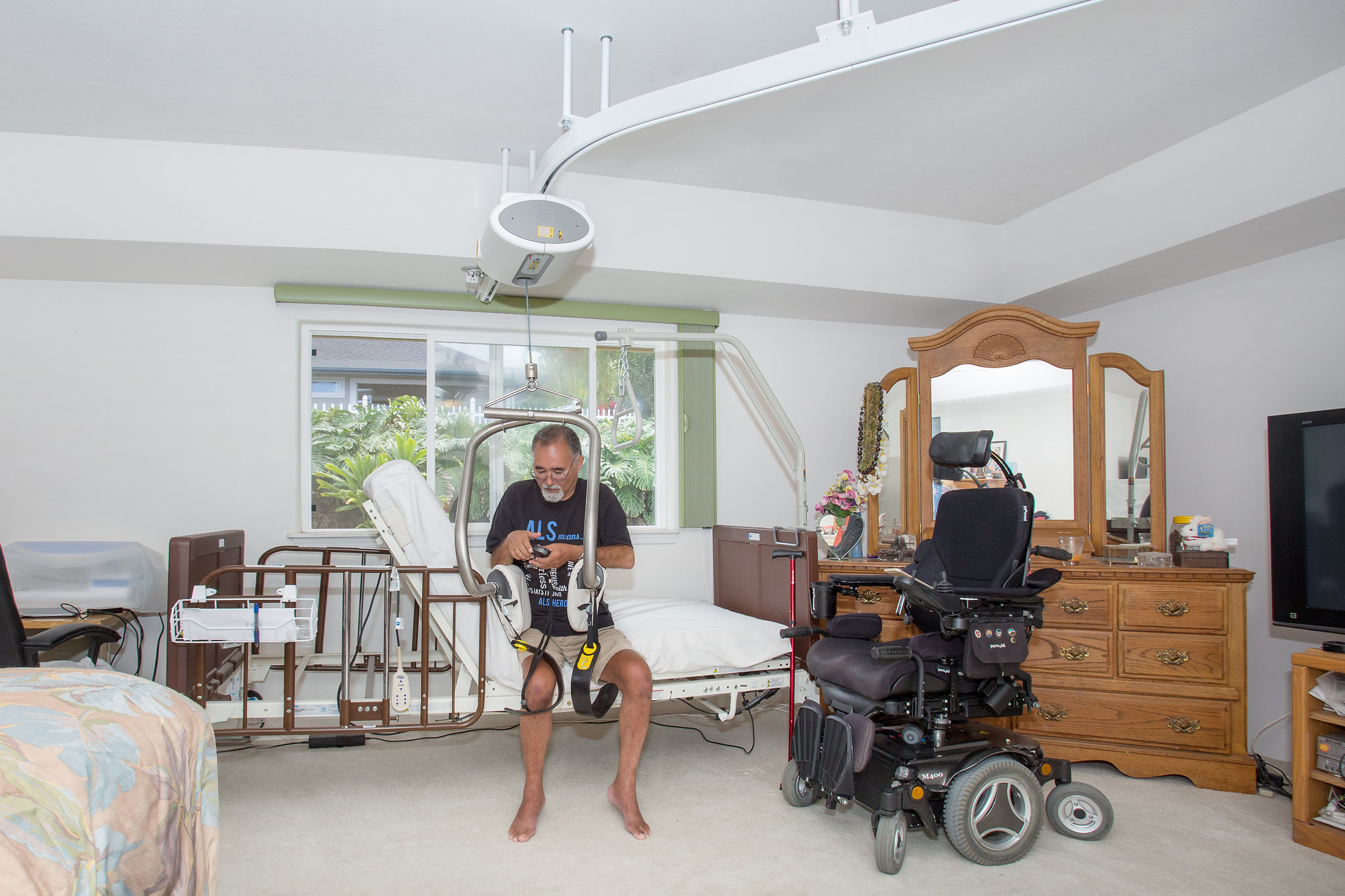 Client using ceiling lift system for safe wheelchair transfer at home