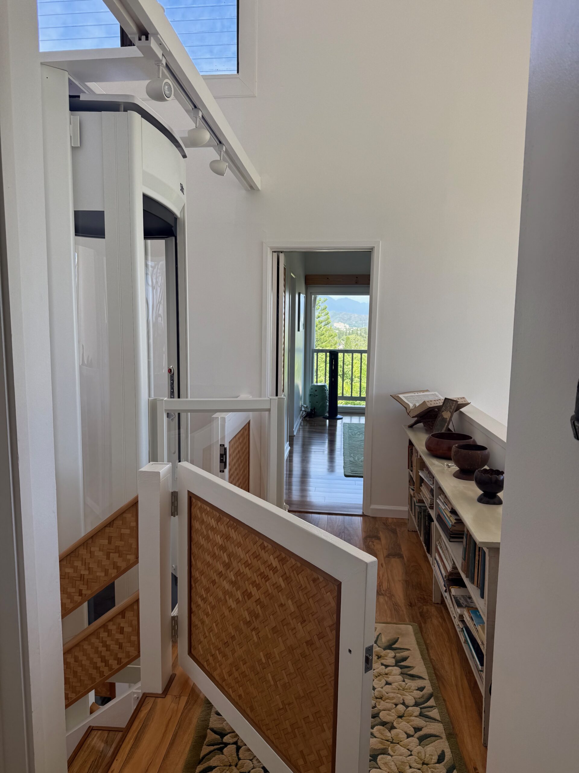 After: Stiltz lift and landing gate beside the same stair panels, rug and bookcase.