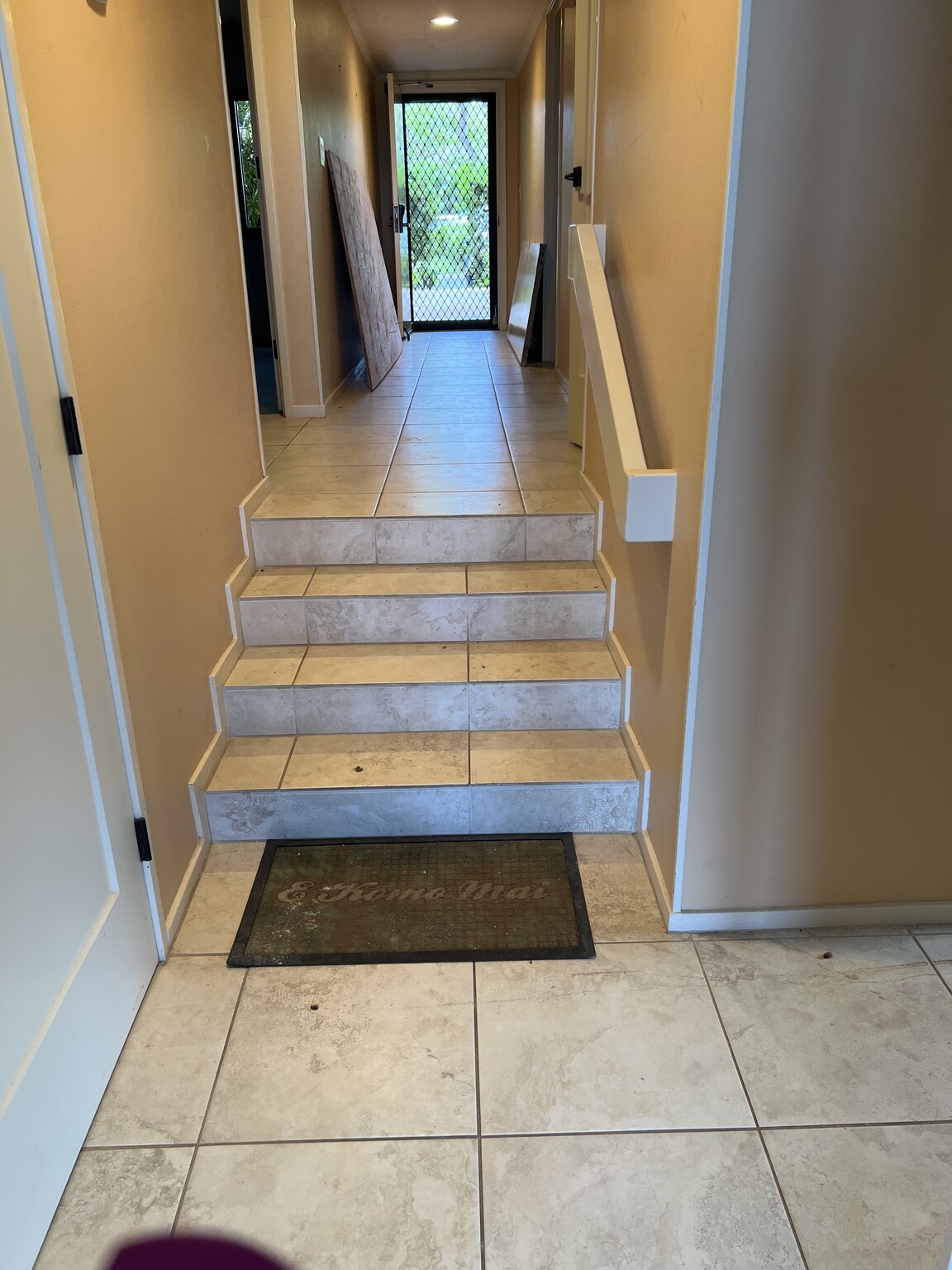 Before FlexStep installation: tiled steps in a narrow residential hallway