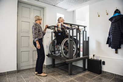 Wheelchair user using FlexStep by Liftup platform lift inside home